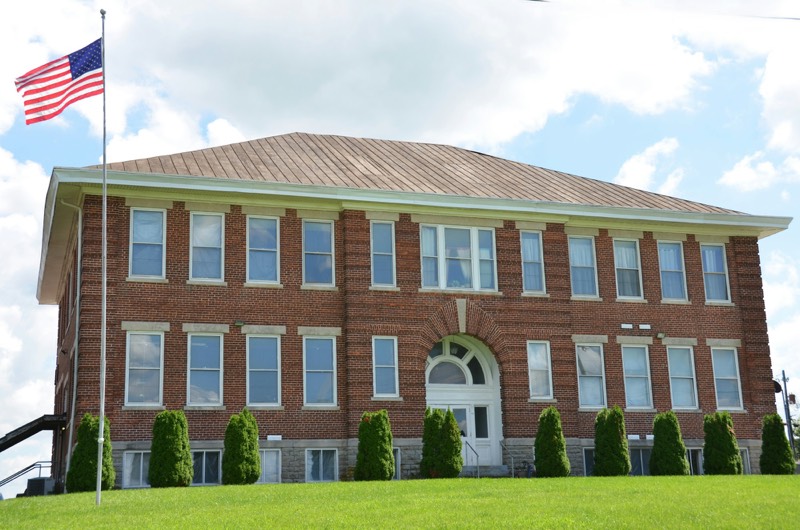 brick school building with a covered entrance